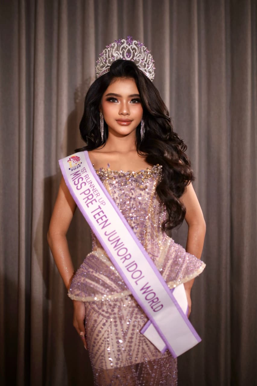Brigitta Alicia Bupu Alfons dengan kostum nasional dan piala penghargaan